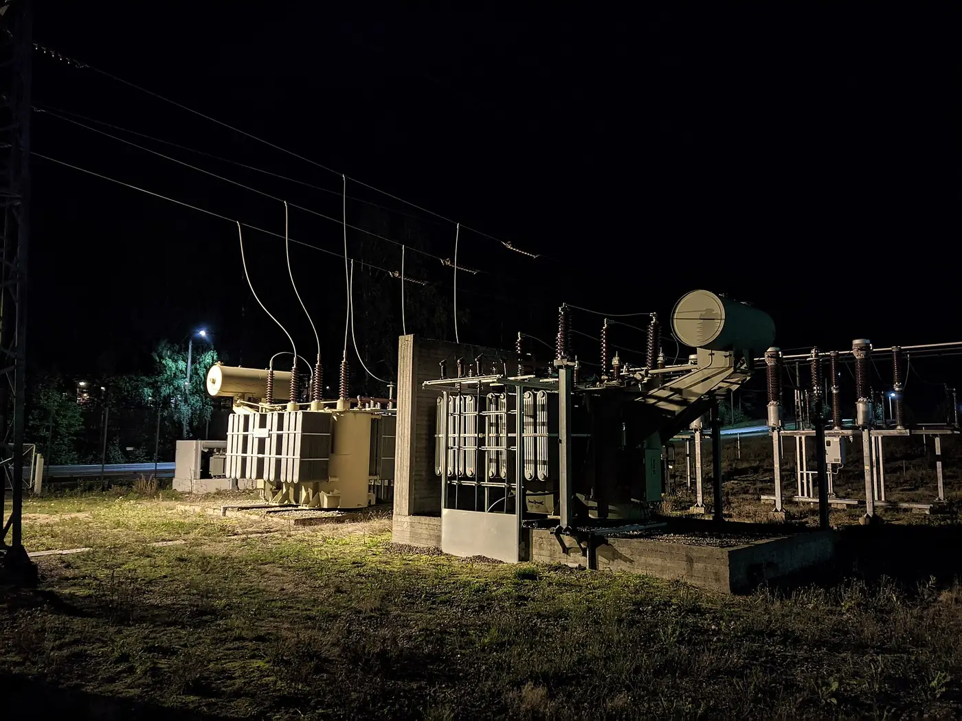 Electrical substation transformers illuminated at night